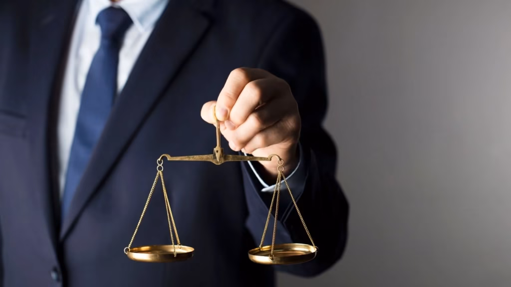 Lawyer in a suit holding golden scales to represent comprehensive legal assistance for associations.
