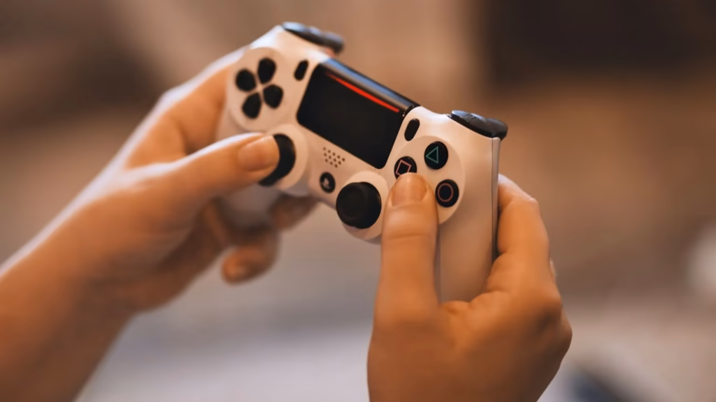 Manos sosteniendo un mando de videoconsola, ilustrando el uso de plataformas gaming para el blanqueo de capitales.
