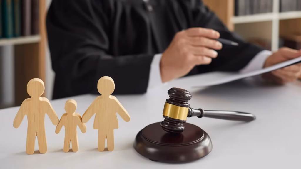 Familienfiguren aus Holz und ein Richterhammer, die Versöhnung in Jugendstrafverfahren darstellen.