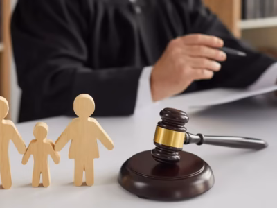 Wooden family figures and judge's gavel illustrating conciliation in the juvenile criminal procedure.