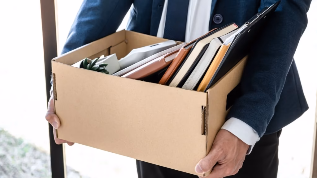 Trabajador con caja de oficina que ilustra la necesidad de tramitar la prestación por desempleo tras un ERTE.