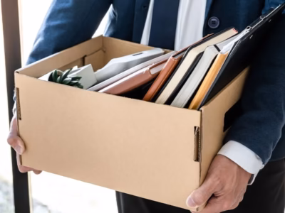 Worker with an office box illustrating the need to process unemployment benefits following an ERTE.