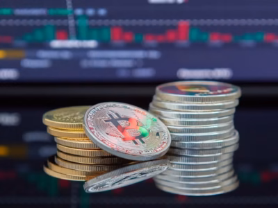 Bitcoin coins in front of a financial chart to provide information on Tax Agency seizures of cryptocurrency wallets.