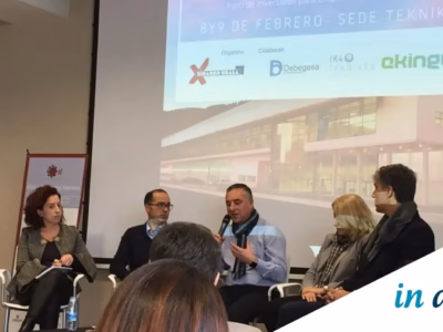 Reunión de profesionales y emprendedores en un foro de inversión con ordenadores y documentos sobre la mesa.