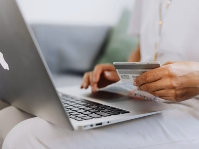 Person making an online purchase with a credit card to illustrate ecommerce payment regulations.