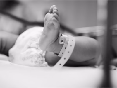 Primer plano del pie de un bebé recién nacido con pulsera de identificación en un hospital.