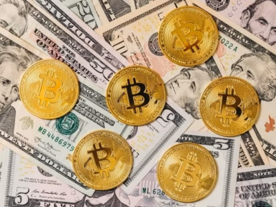 Monedas de bitcoin sobre billetes de dólar para representar la herencia de criptomonedas y patrimonio familiar.