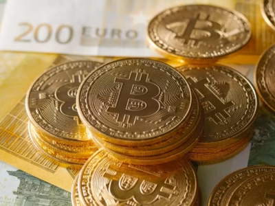 Monedas de Bitcoin sobre billetes de 200 euros ilustrando el control fiscal de criptodivisas por la Agencia Tributaria.