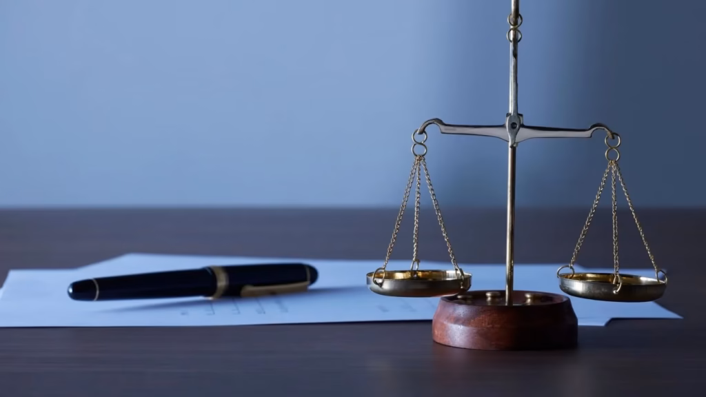 Balanza de la justicia y pluma sobre documentos, representando el control fiscal de la Directiva DAC8 en la UE.