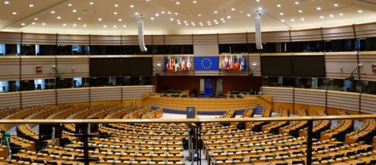 Hemiciclo del Parlamento Europeo con banderas de la UE, representando la normativa DAC8 para criptomonedas.