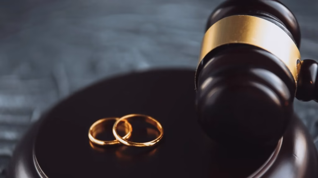 Alianzas sobre mazo de madera para ilustrar las opciones de divorcio de mutuo acuerdo judicial o ante notario.