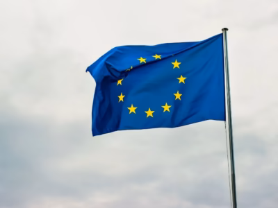 Bandera Unión Europea ondenado al viento en el cielo para ilustrar términos clave del glosario MiCA.
