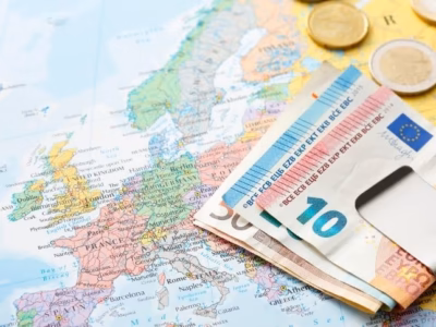 Monedas y billetes sobre mapa de europeo para ilustrar la responsabilidad penal de empresas por blanqueo de capitales.