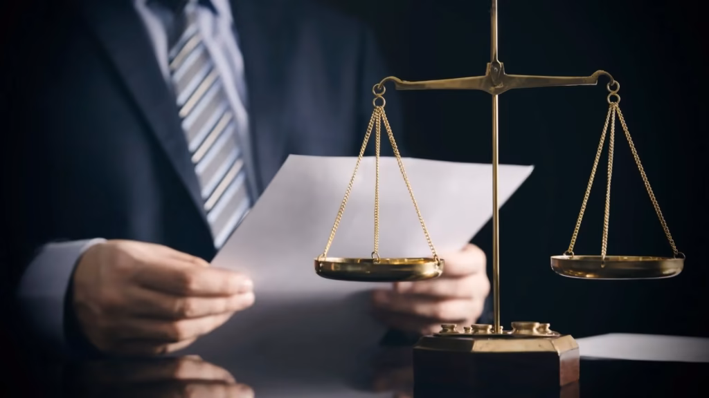 Balanza de la justicia frente a un abogado revisando protocolos de cumplimiento normativo y compliance.