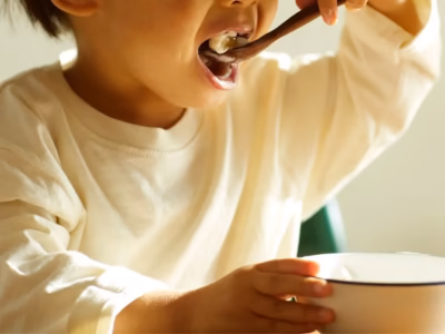 Young child eating from a bowl with a spoon. Calculation of child support. 