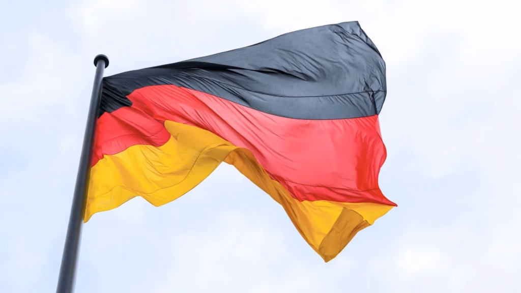 Bandera Alemania ondenado al viento en el cielo utilizada para ilustrar la tipología de sociedades mercantiles alemanas.