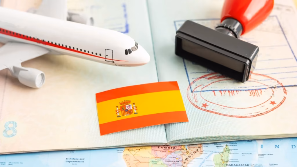 Pasaporte con sellos, bandera de España y avión miniatura ilustrando la vía rápida para la nacionalidad española.