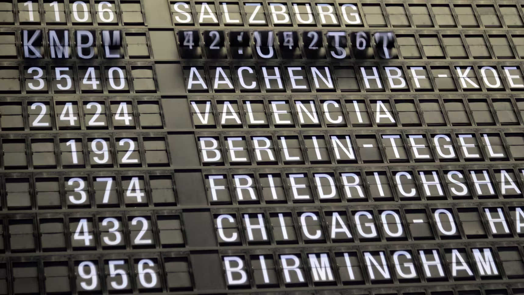 Panneau d'information sur les départs d'un aéroport international illustrant un refus d'entrée et les contrôles aux frontières en Espagne.