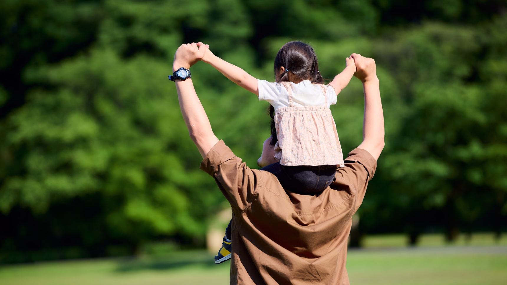 Padre con su hija sobre los hombros como representación de la filiación internacional y el reconocimiento de la paternidad.