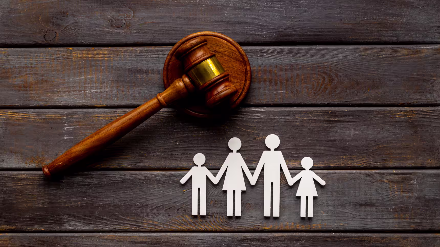 Mazo judicial junto a figuras de una familia como representación del reconocimiento y ejecución de sentencias familiares extranjeras.
