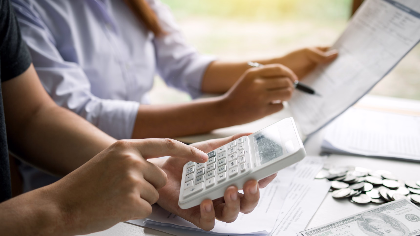 Pareja revisando documentación y realizando cálculos económicos como representación del régimen económico matrimonial internacional.