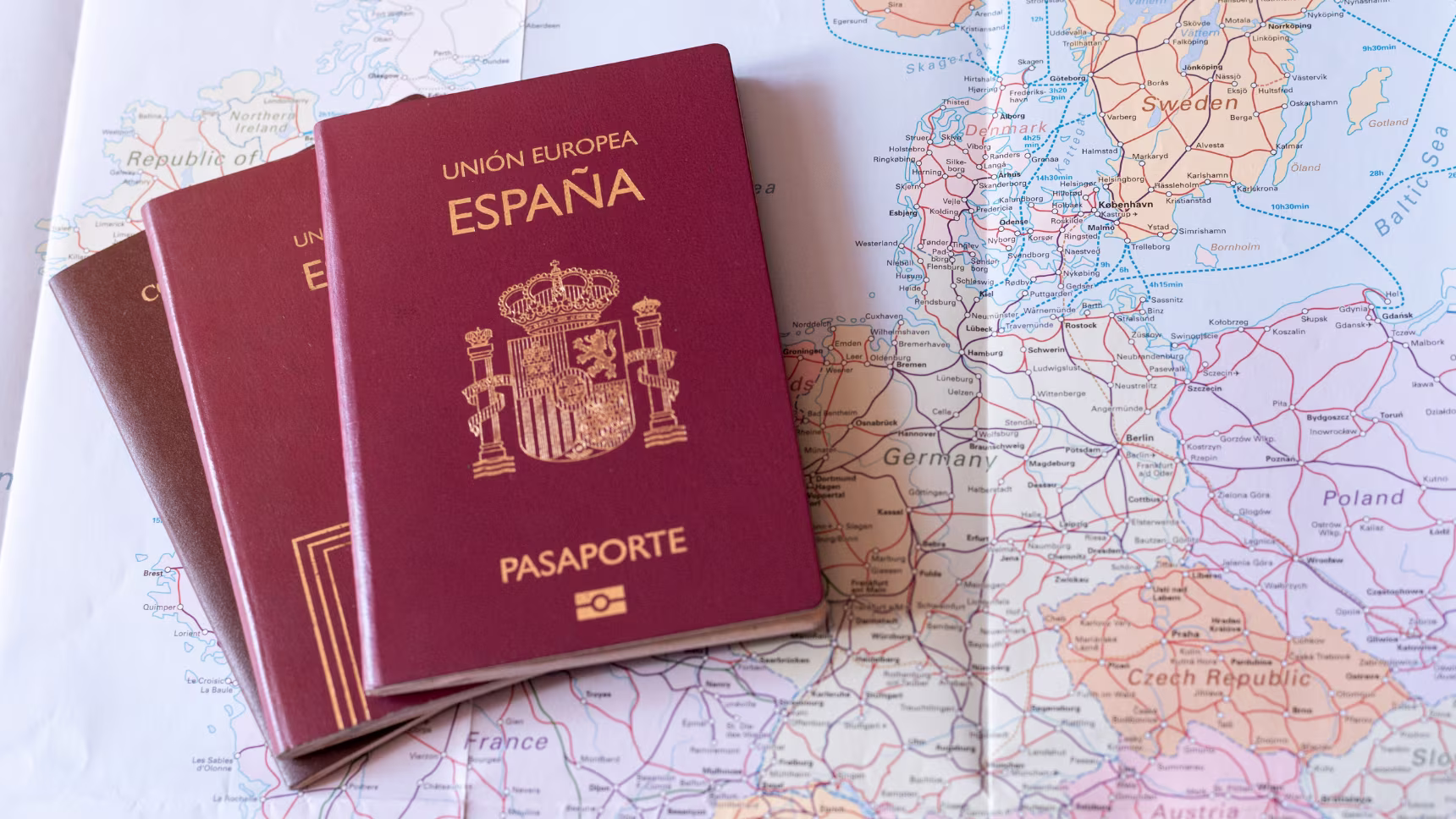 Pasaportes españoles sobre un mapa de Europa para ilustrar el arraigo social en España