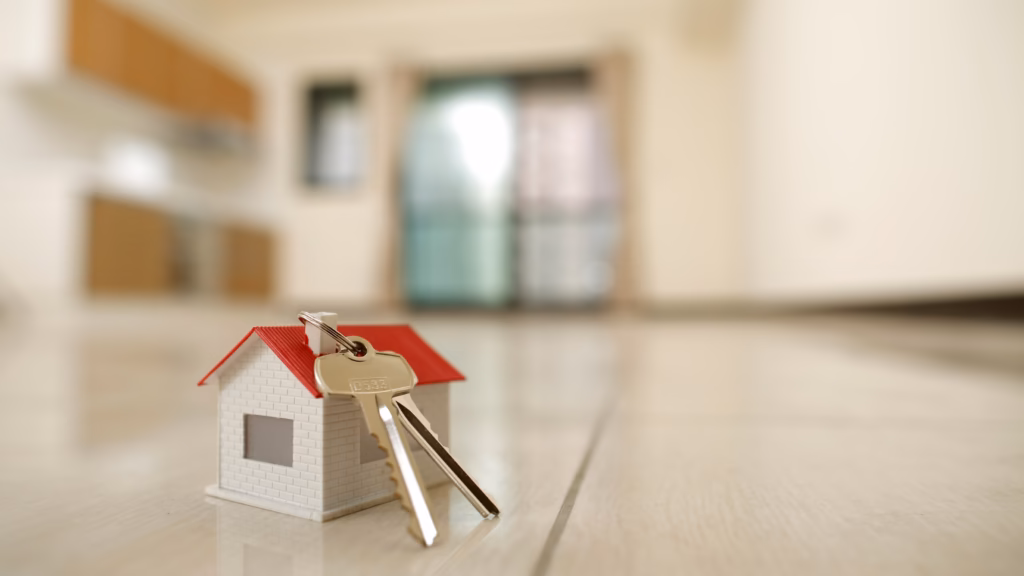Maqueta de vivienda con llaves para ilustrar un contrato de arras en una compraventa inmobiliaria