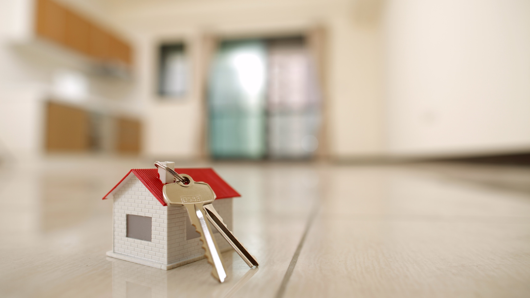 Maqueta de vivienda con llaves para ilustrar un contrato de arras en una compraventa inmobiliaria