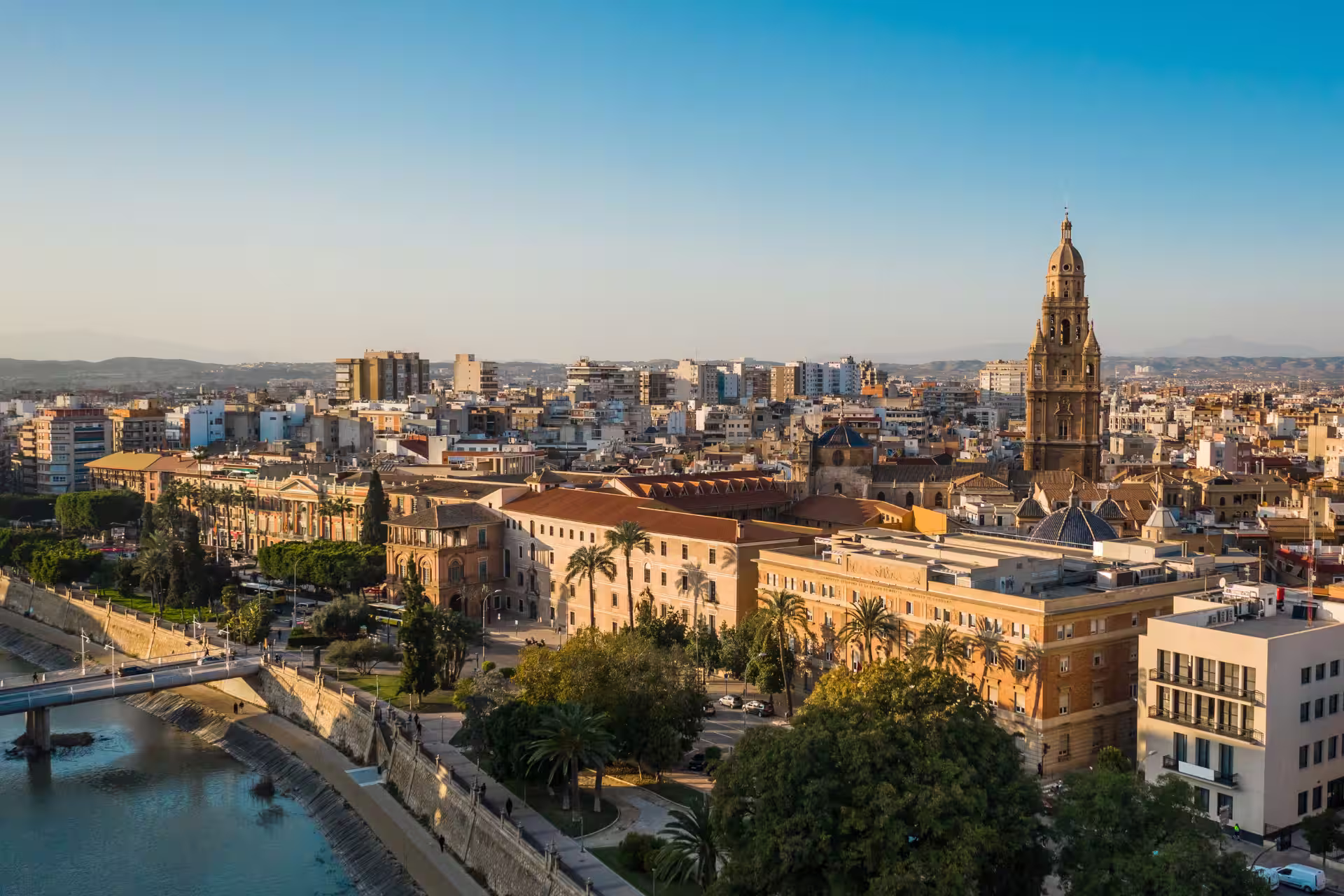 Vista panorámica del centro histórico de Murcia con la torre de la Catedral y edificios junto al río Segura.