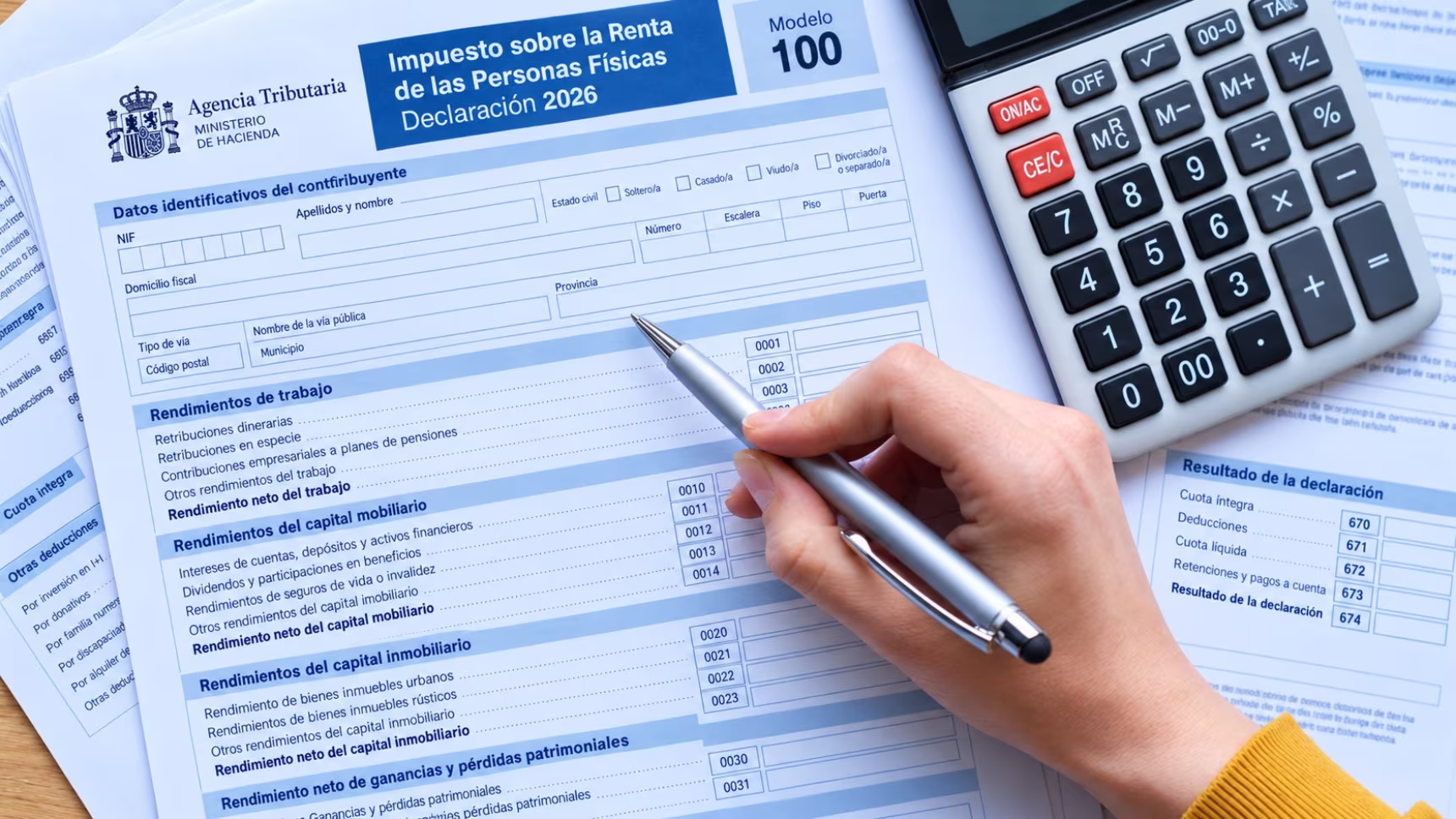 Primera declaración de la renta en España con ingresos del extranjero: formulario del IRPF, calculadora y bolígrafo.
